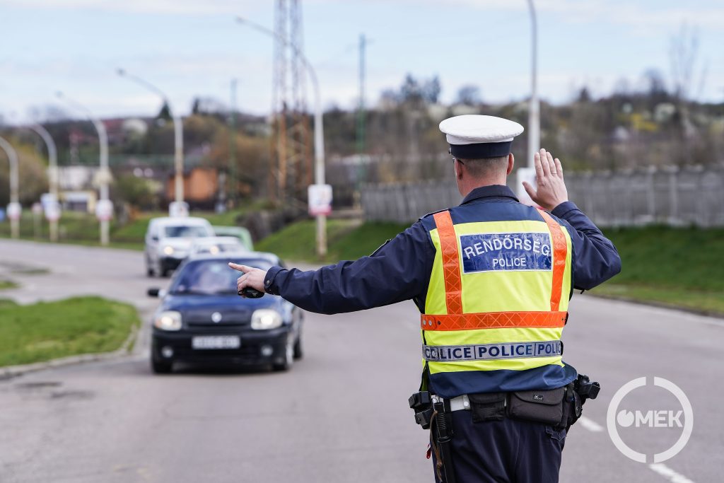 A közlekedésrendészeti osztály munkatársa kiint egy autóst a forgalomból.