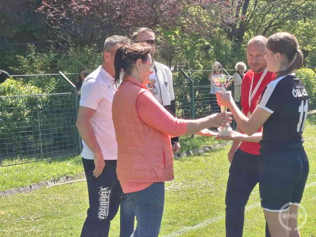 Az egyik játékos átveszi a kupát.