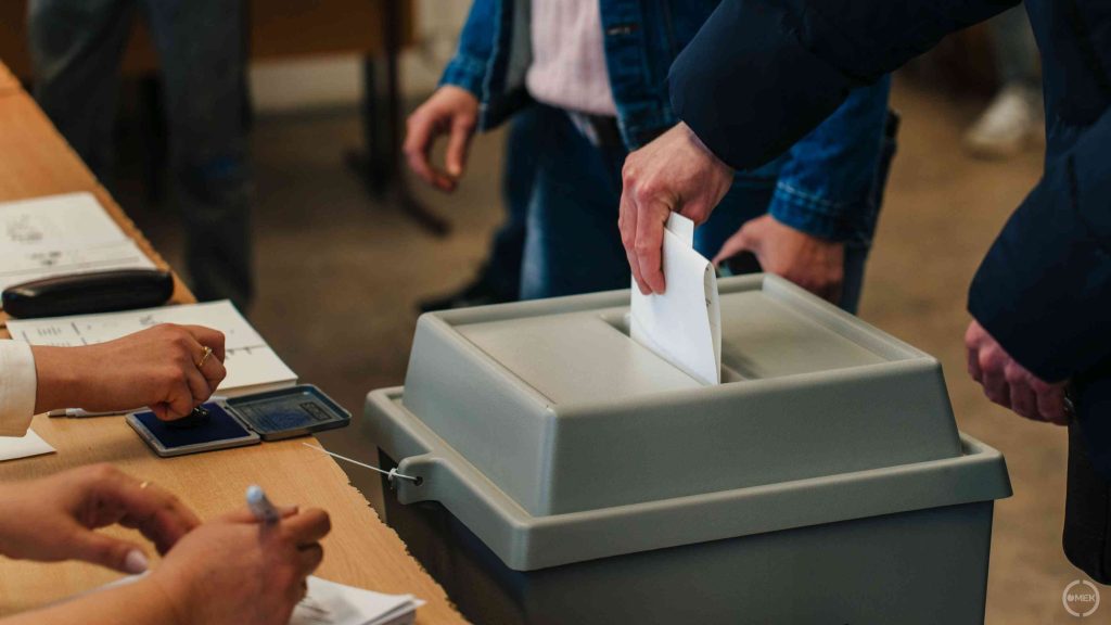 Bedobják az urnába a szavazóíveket.