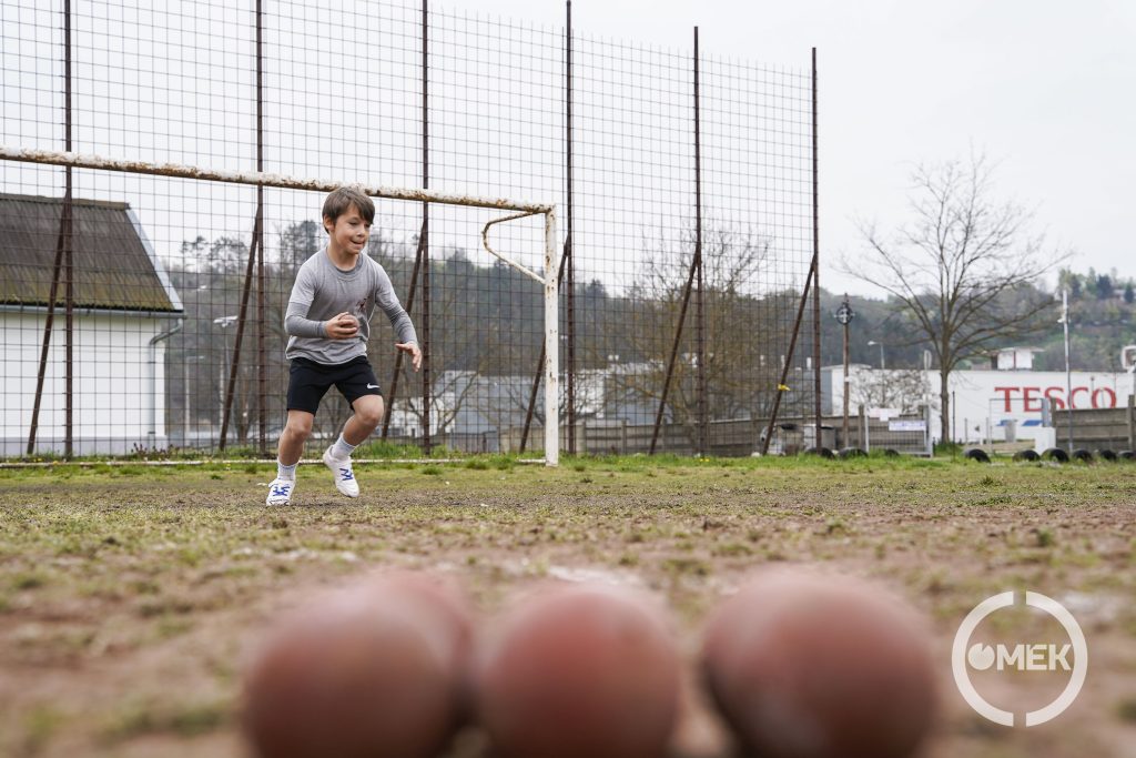 Távoli kép egy kisfiúról, elől kislabdák.