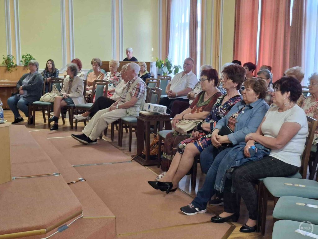 A jelenlévők érdeklődve hallgatják a beszélgetést.