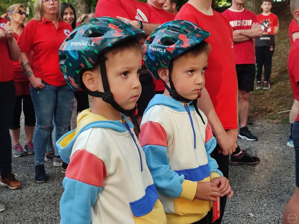 Két kisfiú kerékpáros bukósisakban a rajtzónában.