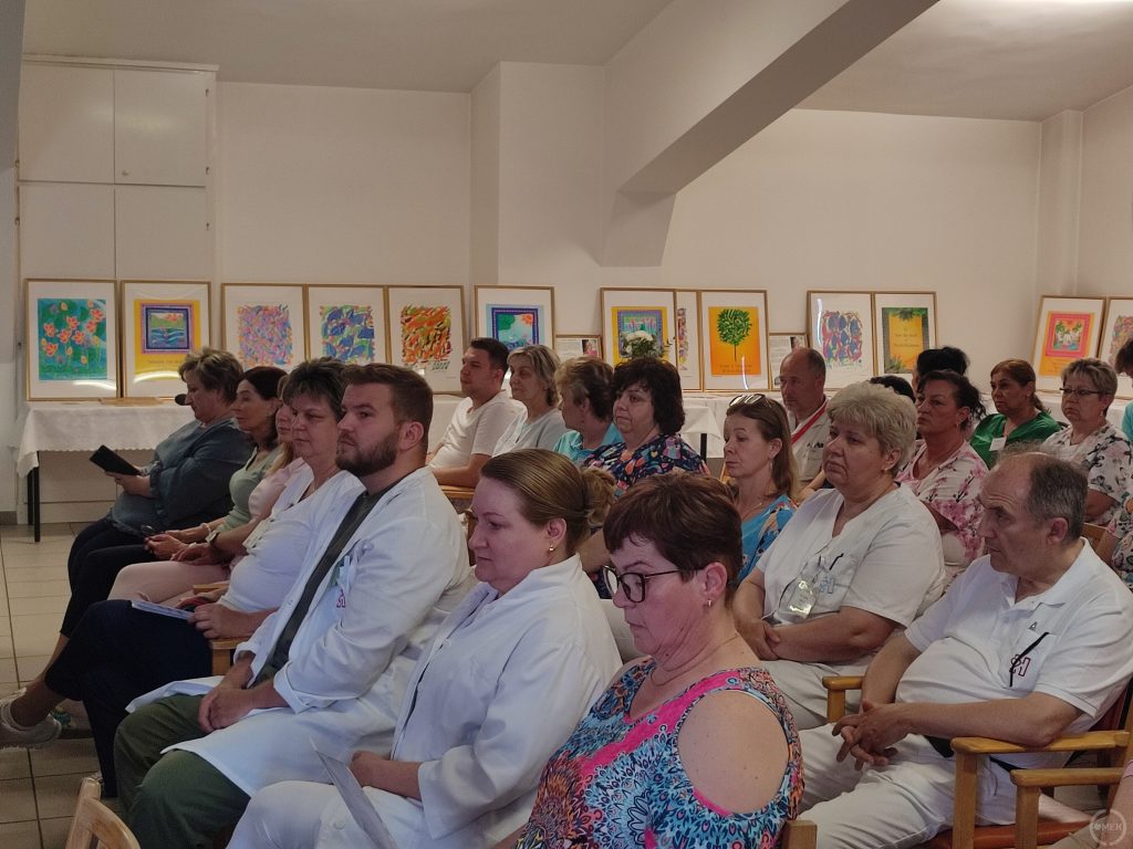 A kórház dolgozói hallgatják az előadást.