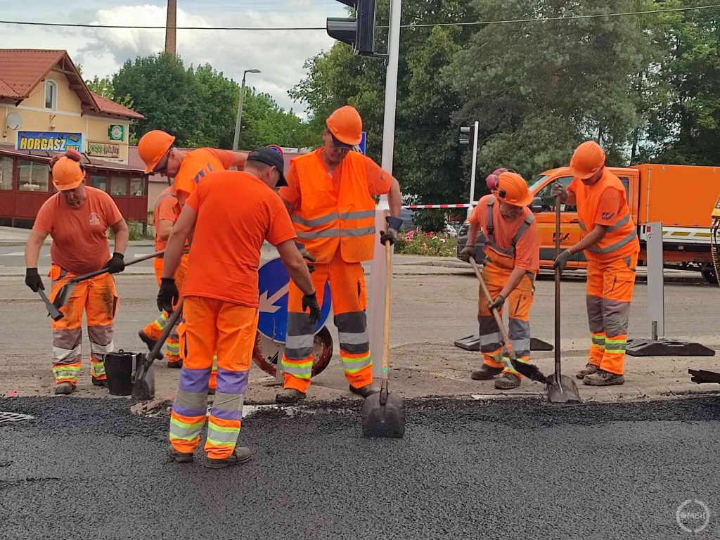 A Magyar Közút dolgozói egyengetik a friss aszfaltot.