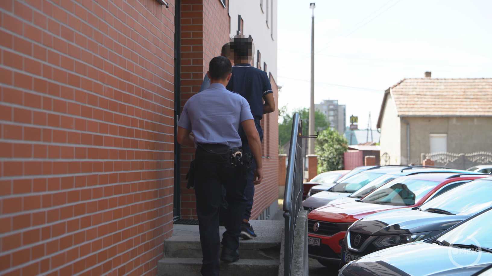 Bilincsben kísérik a járásbíróságra a tolvajt a rendőrök.