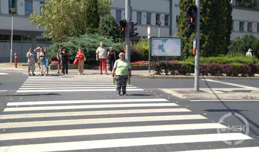 Gyalogosok kelnek át a zebrán.