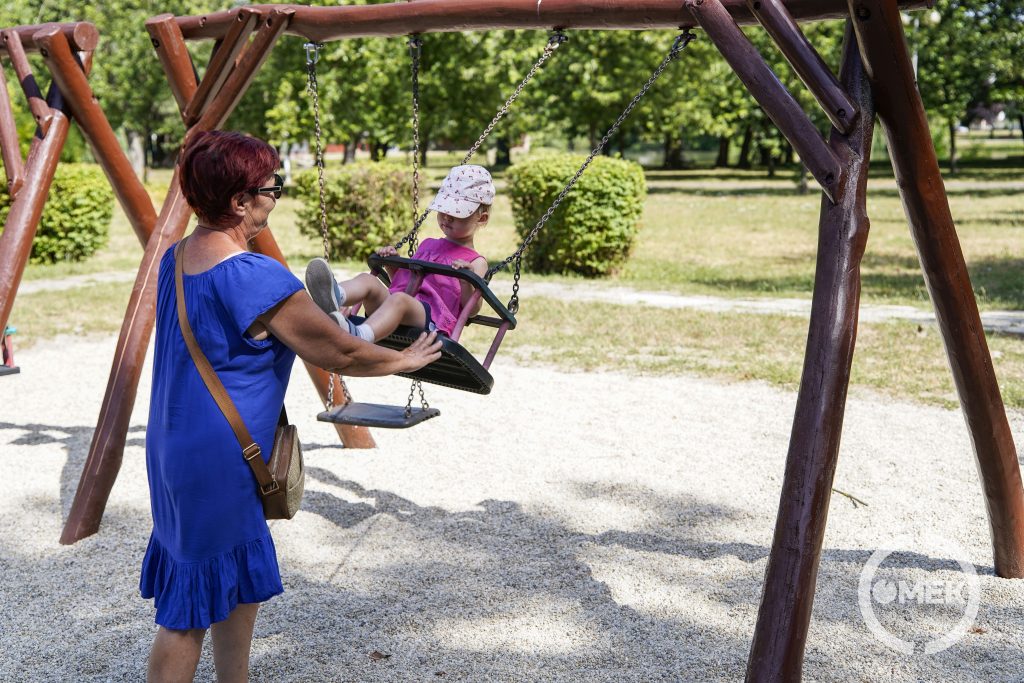 Mamája hintáztatja a kislányt.