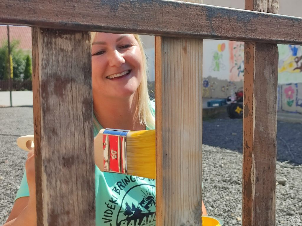 Eke Eszter, az ötletgazda festi a kerítést.