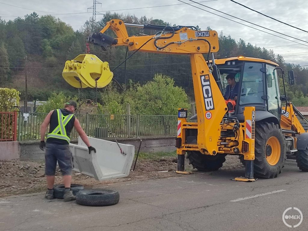 Egy mederelemet emel a magasba egy munkagép Urajon.