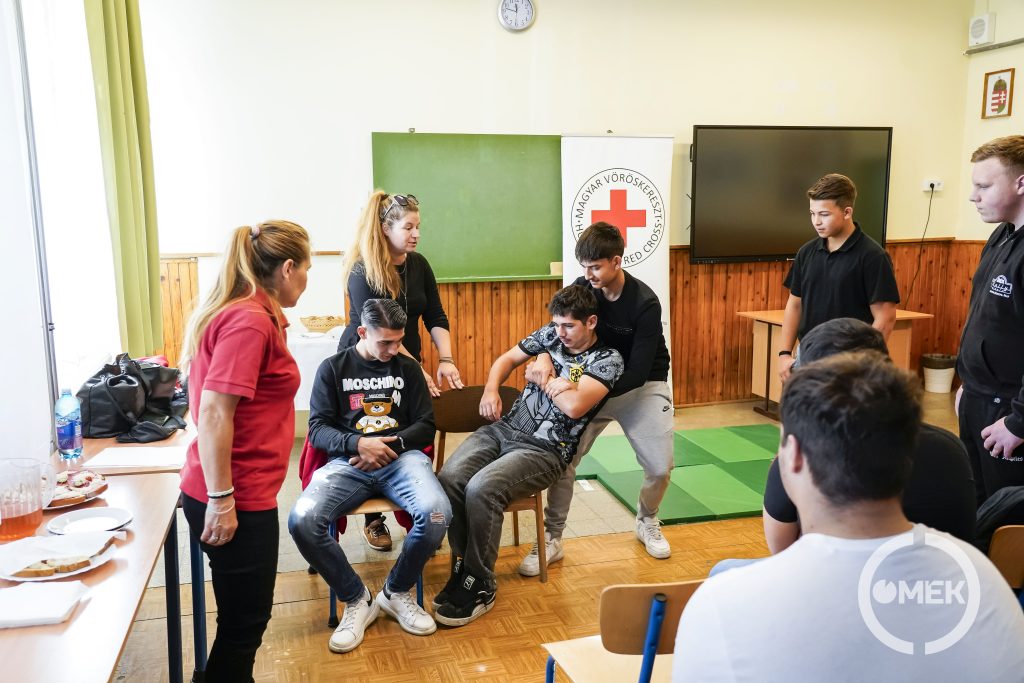 A diákok gyakorolják, hogy hogyan kell kihúzni az autóból egy eszméletlen személyt.