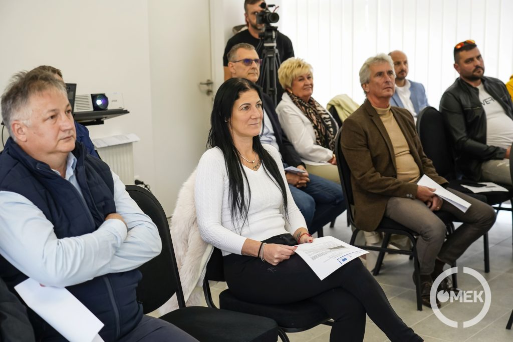A meghívott vendégek figyelik a projektről szóló előadást.