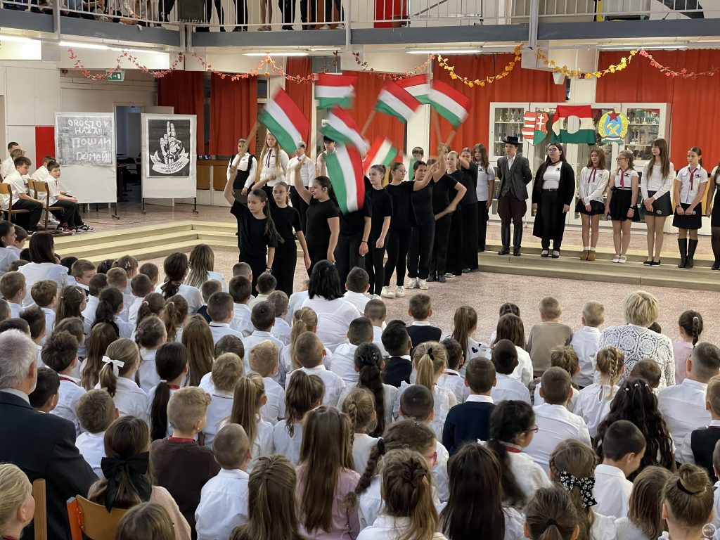A zászlós koreográfiát mutatják be a feketébe öltözött diákok.