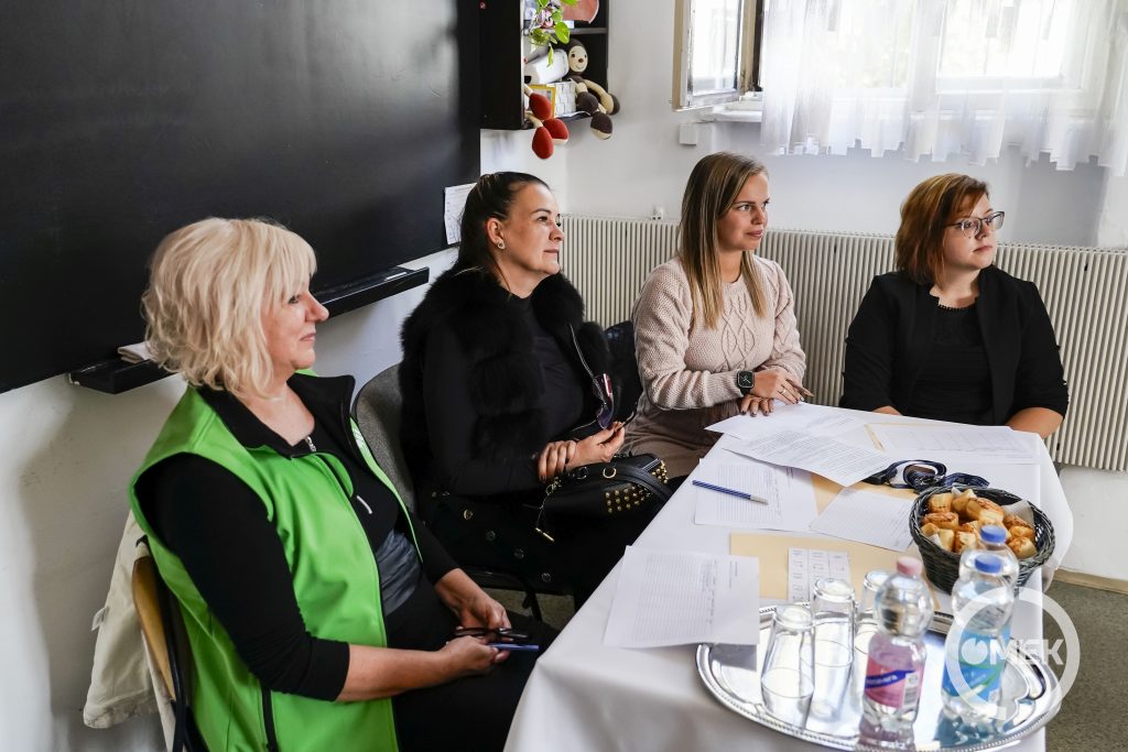A zsűri tagjai hallgatják az előadást.