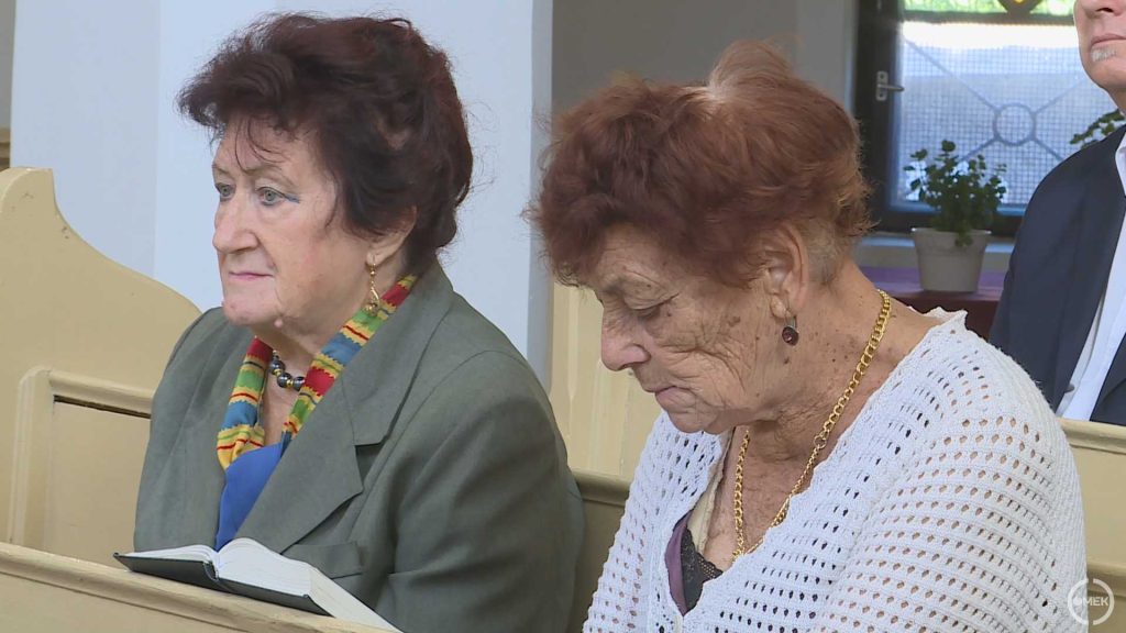 Idős hölgyek a padsorokban.
